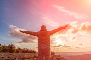 The girl at sunset. The girl stands with her back on the top of photo