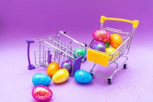 Happy Easter background. Easter eggs are colorful in a shopping basket on purple paper. Holiday concept. Copy space for text. photo