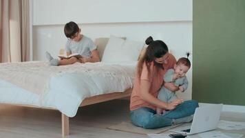 casa isolamento, famiglia quarantena, opera a partire dal casa, libero professionista donna, a distanza attività commerciale. attività commerciale mamma Lavorando a partire dal casa utilizzando il computer portatile Il prossimo per bambini video