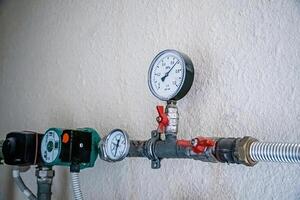 Water supply and heating pipes with pressure sensors and manometers. photo