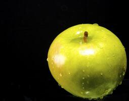 Green apple with water droplets photo