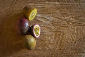 Juicy of passion fruit and kiwi on a wooden background photo