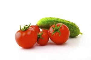 Ripe tomatoes on a branch and cucumber on a white background photo