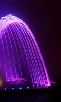 Coloured water fountain at night photo