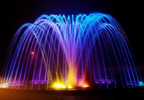 Coloured water fountain at night photo