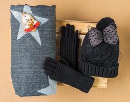 Set of winter cap, scarf and gloves on colored background photo