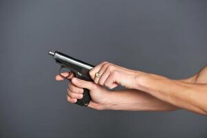 Hand with gun isolated on grey background photo