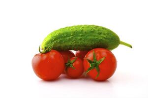 Ripe tomatoes on a branch and cucumber on a white background photo