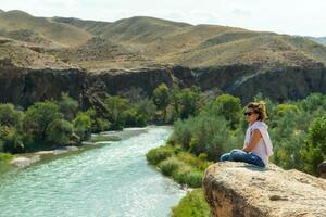 Happy young woman at beautiful view of canyon, travel in Kazakhstan photo