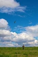 A Man flying his kite at the steppe photo