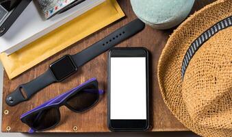 Packed suitcase of vacation items on wooden background. photo