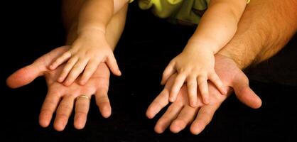 Daughter holds the hand of the father photo