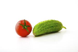 Ripe tomatoes on a branch and cucumber on a white background photo