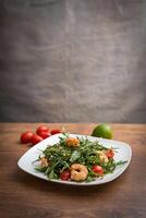 A delicious salad with arugula, cherry tomatoes and shrimps. photo