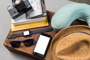 Packed suitcase of vacation items on wooden background. photo