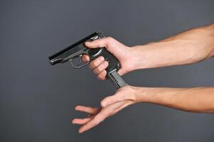 Hand with gun isolated on grey background photo