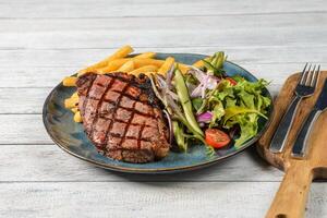 Grilled steak and fresh vegetables for a healthy meal in a kitchen setting. photo