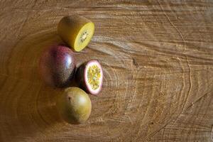 Juicy of passion fruit and kiwi on a wooden background photo