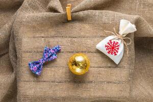 Bow ties and chistmas bag on natural sackcloth background photo