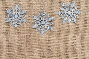 Snowflakes natural on sackcloth background. Winter holidays concept photo