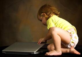 pequeño niña trabajos con el computadora foto