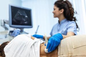 Doctor conducts ultrasound examination of patientv kidneys. Internal organs ultrasound concept. female's lower back diagnosis carried out with the use of an ultrasound photo