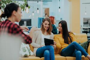 grupo de multiétnico colegas trabajando en escritorio ordenadores, ordenador portátil y compartiendo su ideas en un moderno oficina espacio.joven influencers trabajo en en línea márketing proyectos foto