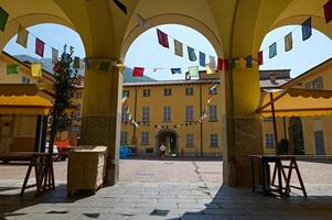 A wonderful courtyard decorated with colorful multi colored flags in medieval Italian Canzo town, Lombardy. Italy photo