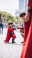 grave valiente hombre mantiene manos en cintura usa rojo máscara y capa protector casco mira a gracioso niño quien obras de teatro con juguete hecho a mano cohete imagina siendo superhéroes con sobrenatural, generativo ai foto