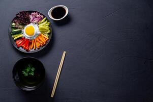 Korean dish, with a variety of appetizers with vegetables and eggs. Diet. bibimbap. View from above. Round plate. Text space. photo