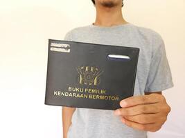 Indonesian book vehicle owners or commonly known as Buku Pemilik Kendaraan Bermotor BPKB. holding BPKB photo