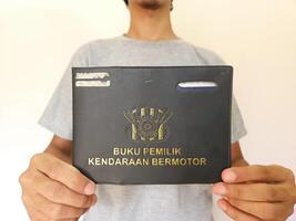 Indonesian book vehicle owners or commonly known as Buku Pemilik Kendaraan Bermotor BPKB. holding BPKB photo