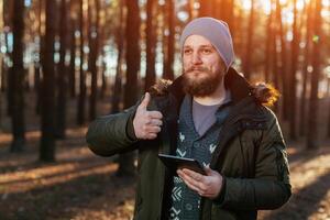 portrait of a bearded hipster tourist man in the woods forest photo