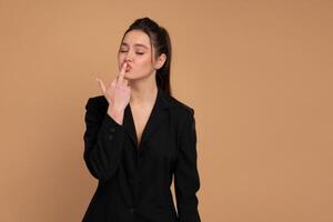 Business woman showing abuse gesture. Irritated smiling female in business suit showing middle finger, impolite rude gesture of disrespect, expressing hate and aggression in conflict photo