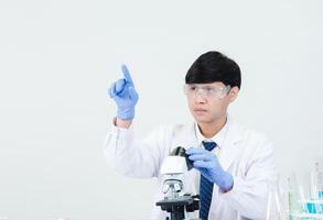 Portrait asian man student scientist doctor in shirt gown one person wokk job plant looking hand holding control microscope on white table see the results of scientific experiments inside laboratory photo