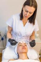 A cosmetologist-esthetician treats problem skin photo