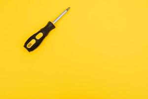 black and yellow screwdriveron a yellow background with space for text. Tools, construction and workshop, home repairs, slusar work photo