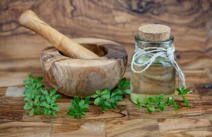 green Woodruff vinegar on olive wood photo