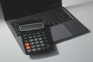 Flat lay, top view office table desk. Workspace with calculator,pen,laptop on white background.Copy Space for text,Empty Blank to word.Business Finance,Education Technology.Work from home. photo