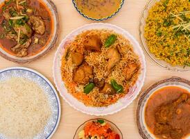 Assorted indian spicy food chicken biryani, Chicken nihari, daal chawal, Daal maash, zarda or jorda rice served in dish isolated on table top view photo