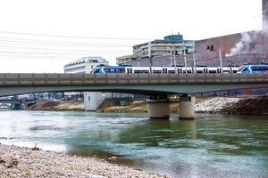 Salzburg, Austria - 01.13.2024 Electric trains travel across the bridge Eisenbahnbrucke in Salzburg. photo