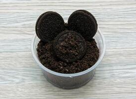 Oreo cookies with powder served in disposable cup side view of indian and pakistani dessert photo