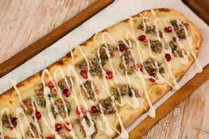 Kofta with jibin pizza bread served in wooden board isolated on background top view of Arabic Manaqeesh photo