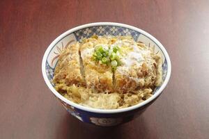 Katsu Don served in a dish isolated on wooden table side view of singapore food photo