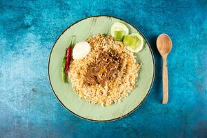 spicy beef pulao, polao, biryani, mandi, kacchi with egg and salad served in dish isolated on table top view of indian food photo