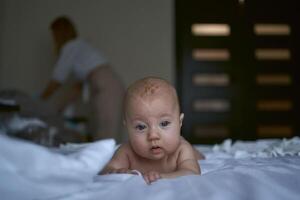 four months old baby lay on the bed photo