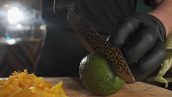 Chef cutting avocado with kitchen knife on cutting board video
