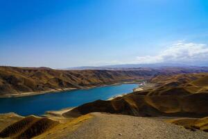 A deserted part of the Zaamin nature reserve in Uzbukistan on a sunny summer day. View of the mountains and reservoir. photo