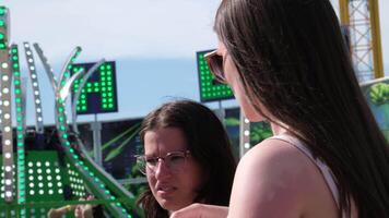 firsty girls drink water from a plastic bottle against the backdrop of flashing attractions Cloverdale rodeo country fair get back to Country family events Canada Vancouver Surrey video