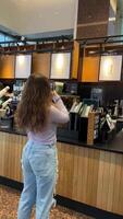 gastos Tempo às starbucks uma jovem menina dentro uma cafeteria comprando machalata levando fotografias encontrado Wi-fi bebendo uma beber tendo uma Boa Tempo jeans lilás blusa de madeira interior Canadá Vancouver video